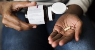 Woman pouring out supplement into her hand