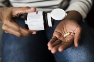 Woman pouring out supplement into her hand