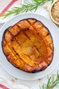 Half a Roasted Acorn Squash on a white plate.