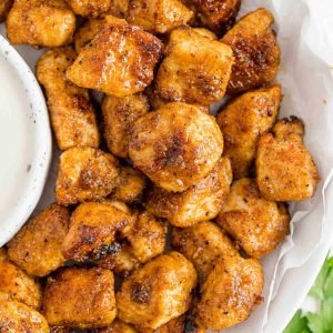 Chicken bites on a plate with ranch dressing.