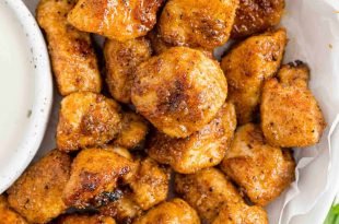 Chicken bites on a plate with ranch dressing.