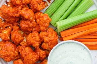 Air Fryer Buffalo Cauliflower on a plate with celery, carrot sticks, and ranch dressing.